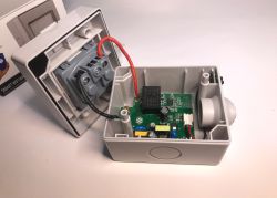 Opened enclosure of an outdoor WiFi socket ATLO-S1IP5-TUYA with visible internal electronics.