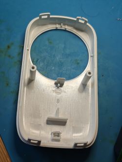 White plastic casing interior with central hole and mounting clips