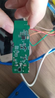 Green PCB with electronic components held by a hand