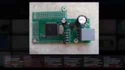 Close-up of a green PCB with an Atmel IC, capacitors, and an RJ45 socket, shown in a webpage screenshot