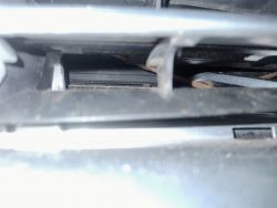 Zbliżenie wnętrza pojazdu, pokazujące linkę i elementy mechaniczne.
