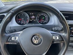 View of a Volkswagen car interior focused on the steering wheel and dashboard.