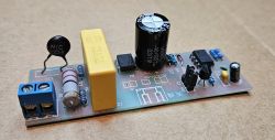 Płytka przerywacza z różnymi elementami elektronicznymi, w tym kondensatorem i rezystorami.