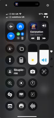 Zrzut ekranu centrum sterowania na iPhonie z widocznymi ikonami ustawień i odtwarzaczem muzyki.