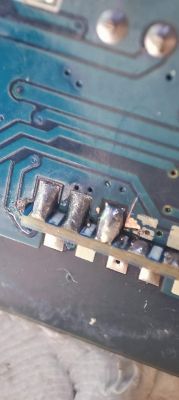 Close-up of a circuit board with soldered pins.