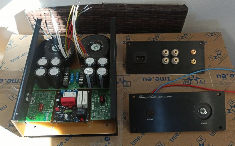 Elementy wzmacniacza audio DIY Rozłożone elementy wzmacniacza audio na tle kartonu.