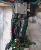 Wnętrze wkrętarki z odsłoniętym silnikiem, przewodami i małą płytką elektroniki w rękojeści