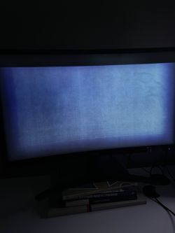 Ekran monitora z jasnym, niebieskoszarym pasem i widocznymi artefaktami na prawie całej powierzchni