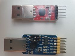 Two USB adapters on a white background. The top adapter is red, the bottom one is blue.