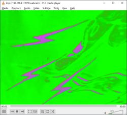 Green and magenta distorted webcam image with zigzag patterns in VLC player