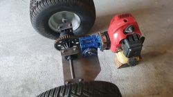 Brushcutter engine connected to gear reducer and axle with large off-road wheels