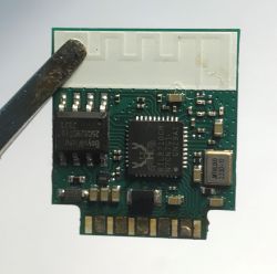Electronic module with RTL8710 chip and PCB antenna held by tweezers