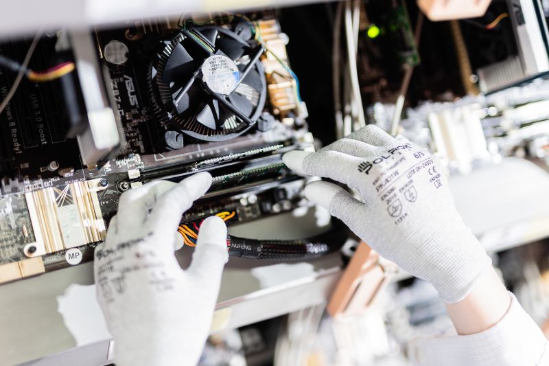 Behandschuhte Hände setzen ein RAM-Modul in die DIMM-Steckplätze eines Desktop-PCs ein.