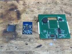 TYWE3S Module and PCB TYWE3S module with open shield next to a circuit board.