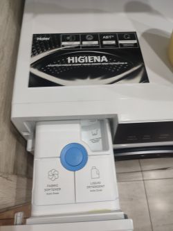 Szuflada dozownika pralko-suszarki Haier z widocznymi komorami na detergent i płyn do płukania