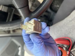 Osoba w rękawiczce trzyma przekaźnik samochodowy Topran w ręku.