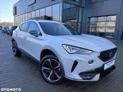 White Cupra SUV parked in front of a showroom with a glass facade