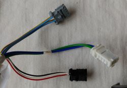 Three electrical connectors with multicolored wires on a light fabric surface