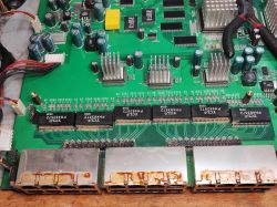 Porty Ethernet na płycie głównej starego switcha z widocznymi śladami korozji i komponentami elektronicznymi.