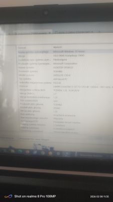 Rozmazane zdjęcie laptopa z oknem Informacje o systemie Windows 10 i danymi Toshiba Satellite C50-B