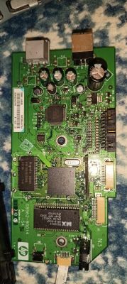 Zbliżenie na zieloną płytkę PCB HP z układami scalonymi, kondensatorami i złączami