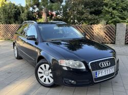 Black Audi station wagon parked on paved driveway, front angled view.