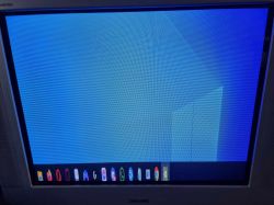 Ekran CRT z wyświetlonym zdeformowanym obrazem pulpitu Windows.