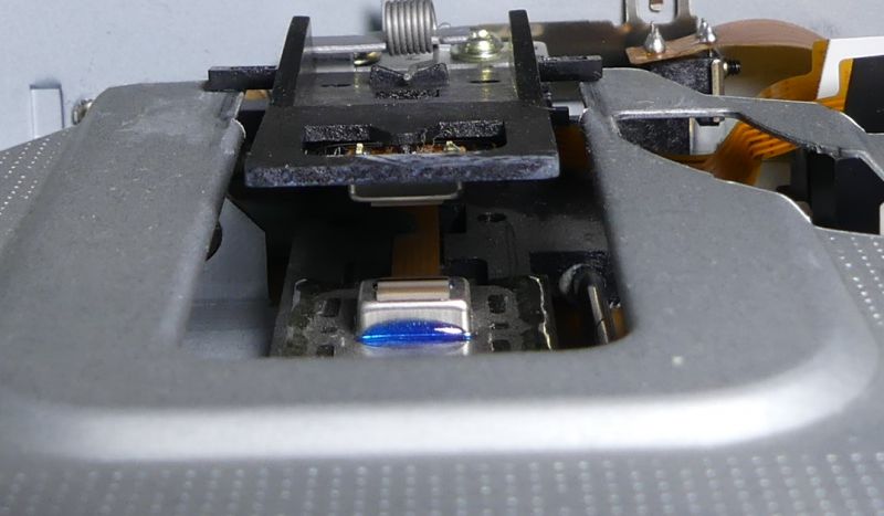 Widok wnętrza napędu dyskietek FDD z widocznymi głowicami i mechanizmem przesuwu.