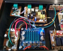 Inside an audio device showing a TPA3110 amplifier module, wiring, and multiple circuit boards in a case