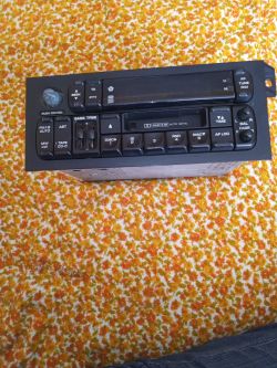 Radio samochodowe leżące na dywanie w odcieniach pomarańczowego.