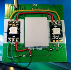 Close-up of a circuit board with green, red, and yellow wires and two Pixel LEDs.