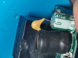 Close-up of a circuit board with a manually soldered capacitor.