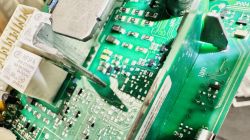 Zbliżenie na płytkę elektroniczną z rezystorami wyglądającymi na uszkodzone.