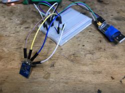 Close-up of an electronic module connected to a breadboard with colored wires.