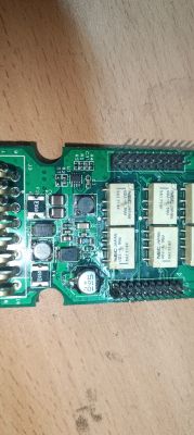 Zdjęcie płytki drukowanej z elementami elektronicznymi, widoczne kondensatory i przekaźniki.