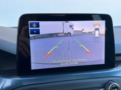 Car's rearview camera display showing a parking lot with a truck.