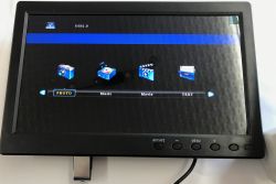 USB 2.0 menu on a small monitor with PHOTO, Music, Movie, and TEXT icons on a dark screen.