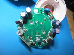 Device circuit board with visible electronic components on a blue background.