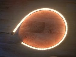 An LED strip in an arc shape emitting warm white light.