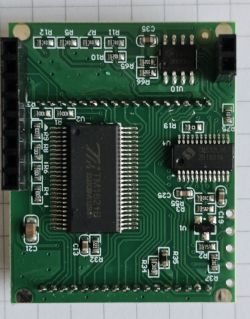 Close-up of a green PCB with ICs and surface-mounted components