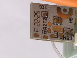 Image of a section of a printed circuit board with various electronic components and markings.
