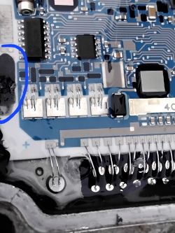 Damage on Opel Astra G ECU Circuit Board Close-up of a circuit board from a control unit with a marked burn mark.