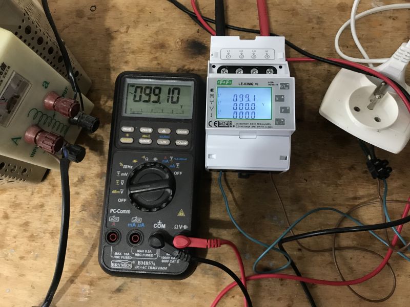 Multimetr i licznik energii elektrycznej F&F LE-03MQ na drewnianym stole.