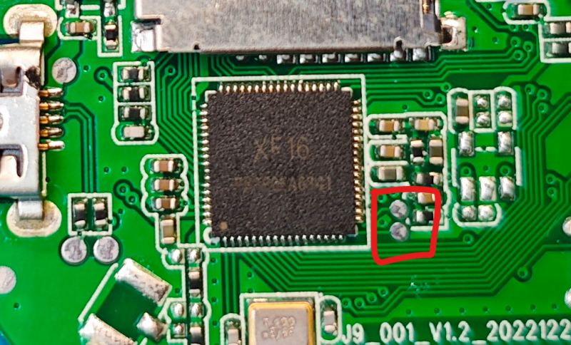 Close-up of a PCB with an XF16 chip and four signal pads highlighted by a red border.