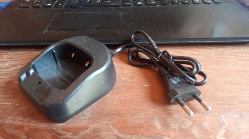Ładowarka biurkowa Baofeng UV-82 z przewodem zasilającym na tle laptopa