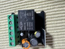 Electronic relay module with various components on a circuit board.
