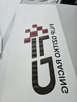 Wydrukowany projekt logo z rozlaną farbą na papierze.