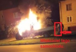Płonący samochód dostawczy przed budynkiem mieszkalnym w nocy, z właścicielem obok.