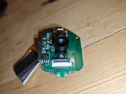 Circuit board with a camera lens module on a wooden surface