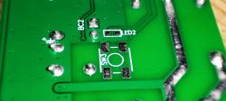 Close-up of a green PCB with clearly visible solder pads labeled SW3 and LED2.
